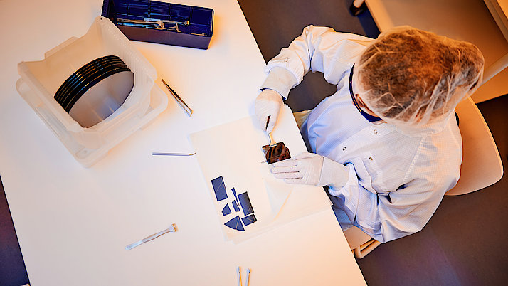 Auszubildende zerteilt einen großen Wafer