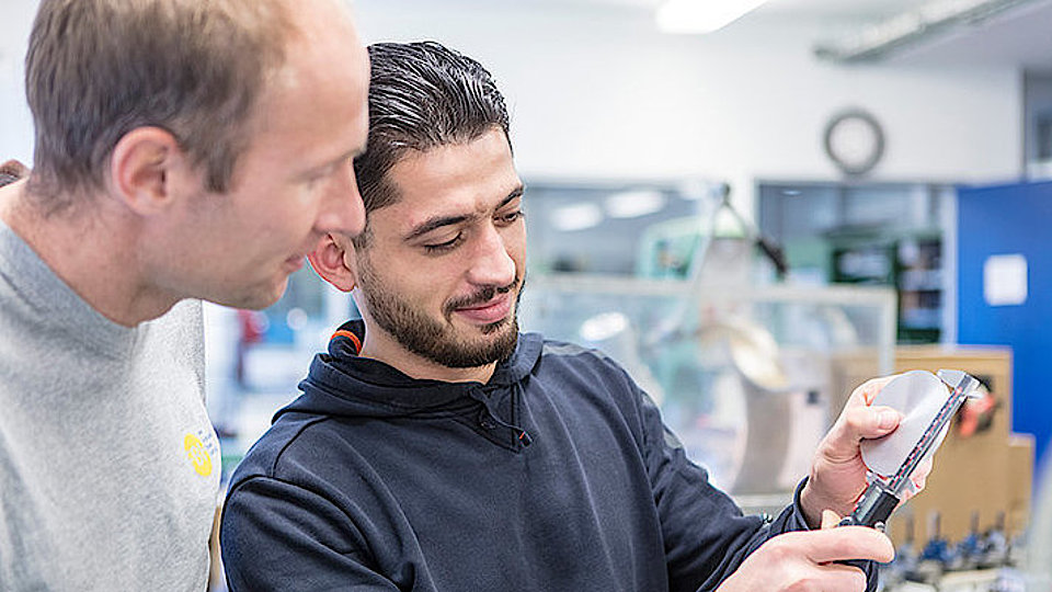 Auszubildender Industriemechanik mit Vorgesetztem bei der Arbeit